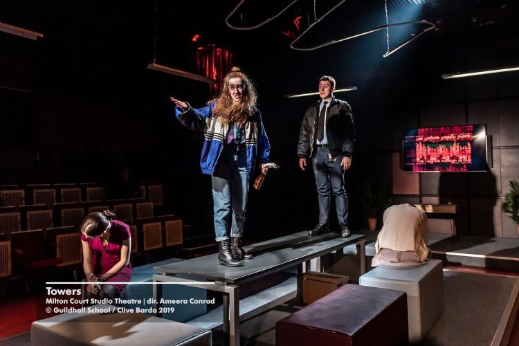 Actors stand on tables